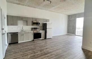 an empty living room with a kitchen in it