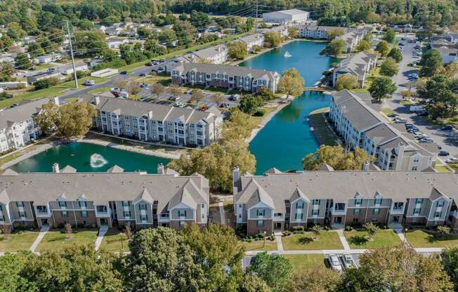 an aerial view of apartments with a lake behind them