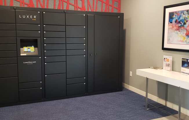 a row of lockers in a room with a table and a painting on the wall