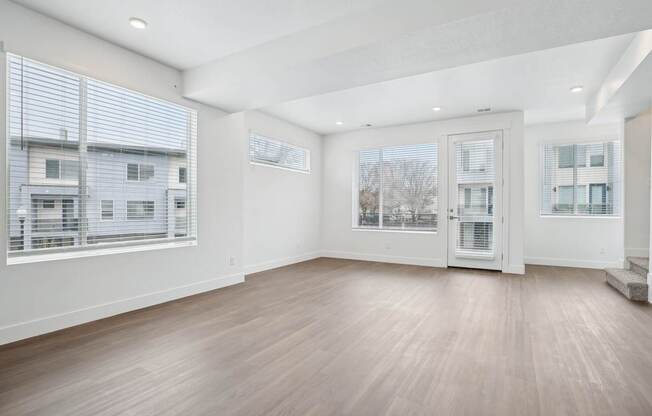 A room with a white door and a window with blinds.