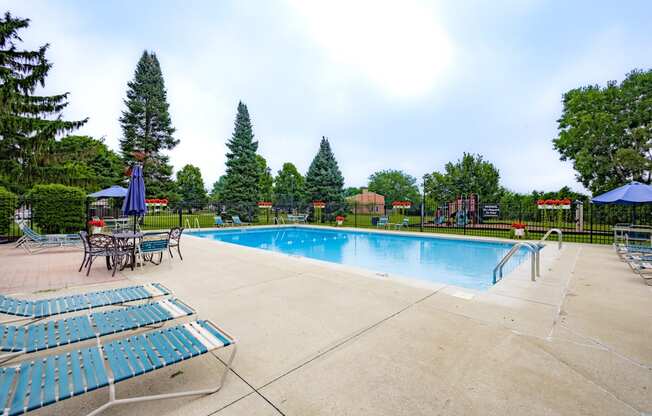 Outdoor swimming pool with seating at University Park Apartments