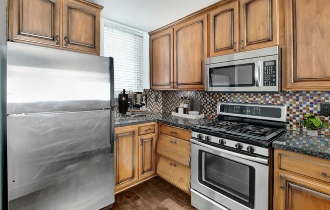 a kitchen with stainless steel appliances and wooden cabinets