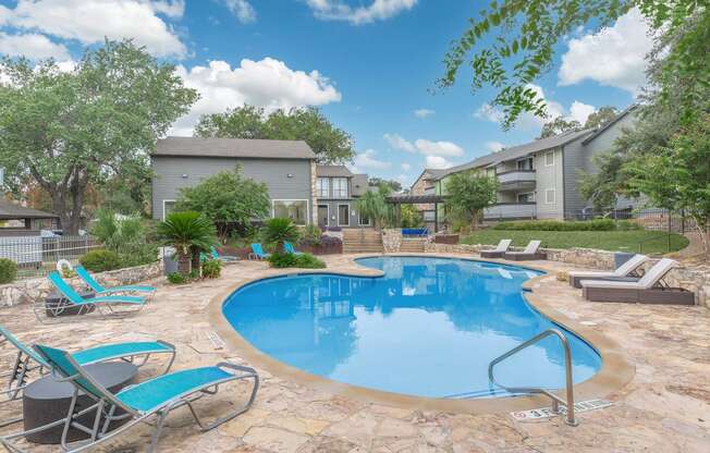 a swimming pool with chairs and a house in the background stock photography