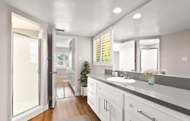 a bathroom with white cabinets and a gray countertop