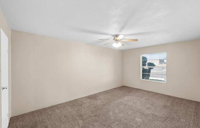 a living room with carpet and a ceiling fan at Brookside Apartments, Hewitt, Texas