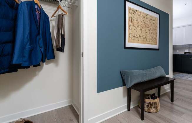 A room with a bench and a coat hanging up.