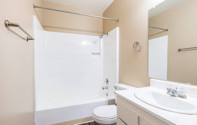 a bathroom with a shower and a sink and a toilet