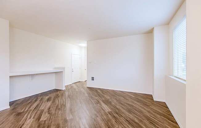 an empty living room with white walls and wood flooring