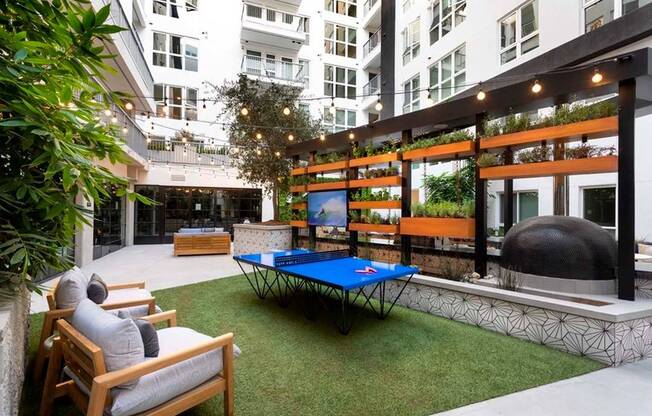 Outdoor games and lounge seating behind the outdoor kitchen in the courtyard at Modera San Diego