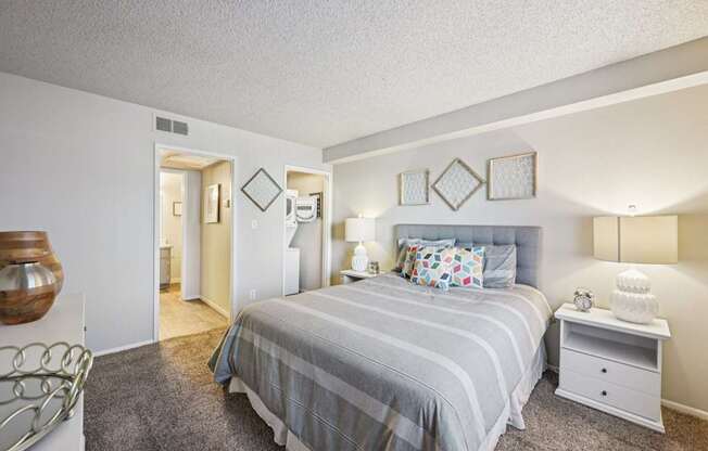 A bedroom with a bed, nightstand, and lamp.