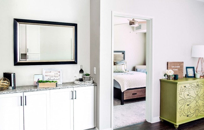 Spacious living room with built-in storage solutions, showcasing a seamless transition to the bedroom. The cozy bedroom, adorned with a soft carpet, invites comfort and relaxation.