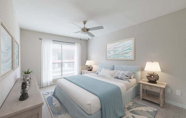 A bedroom with a bed, nightstand, and a ceiling fan.