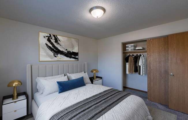 a bedroom with a bed and a closet. Fargo, ND North Manor Apartments