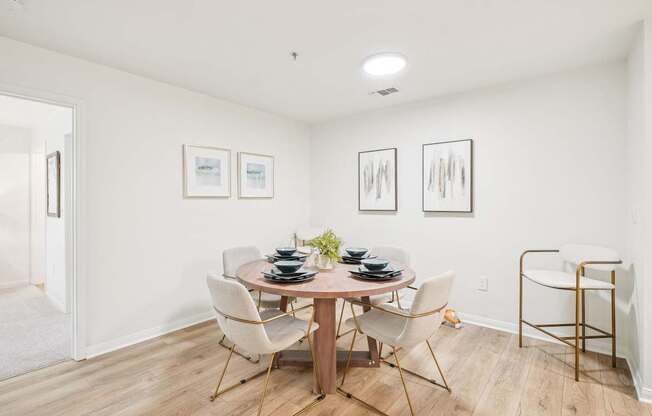 A dining room with a round table and chairs.