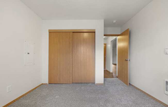A room with a carpeted floor and a wooden door.