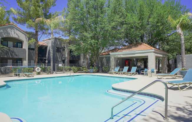 A pool with a slide and a gazebo in the background.