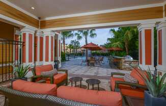 Outdoor lounge area near the grilling area by the pool at The Amalfi Clearwater Apartments