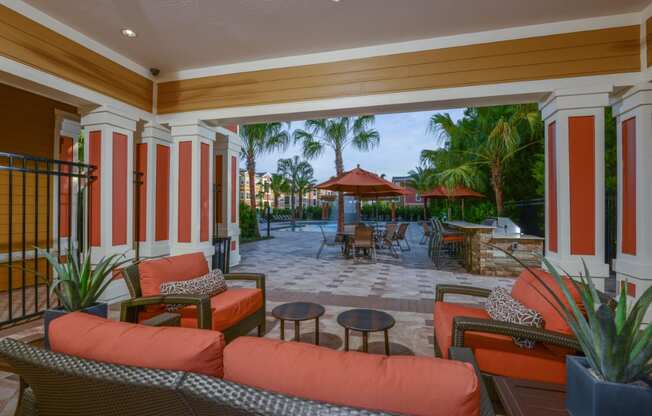 Outdoor lounge area near the grilling area by the pool at The Amalfi Clearwater Apartments