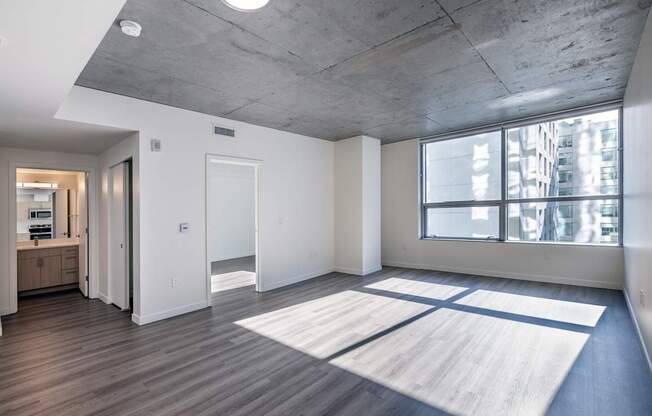 A large open room with a concrete ceiling and a large rug on the floor.