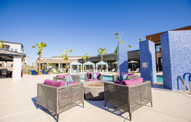 a lounge area with chairs and a pool at a resort