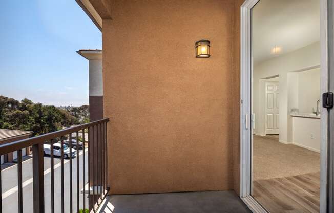 the view from the balcony of a condo with a door open to a balcony door