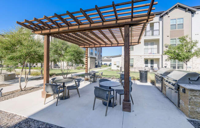 an outdoor patio with tables and chairs and a pergola