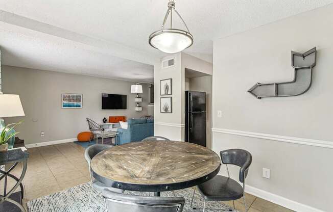 A dining room with a round table and chairs.