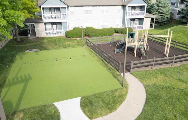 A backyard with a green lawn and a playground.