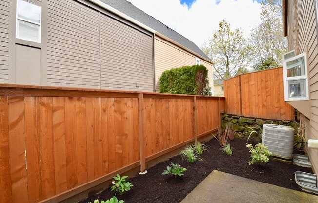 A brown wooden fence with a grey roof and a green plant in the middle.