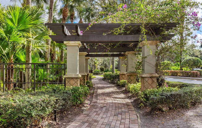 A pathway leads to a covered walkway with a bridge over it.