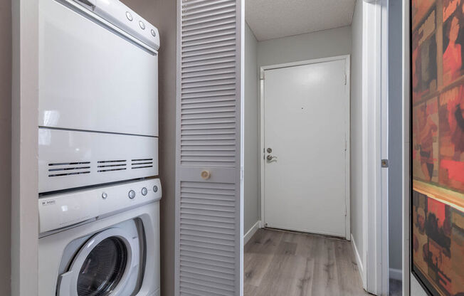 a washer and dryer in a laundry room with a doorat Sunnyvale Crossings Apartments, LLC, Sunnyvale