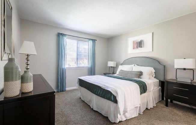 Large master bedroom with plush carpeting, king sized bed and large window