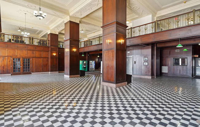 the lobby of a building with a checkered floor and pillars