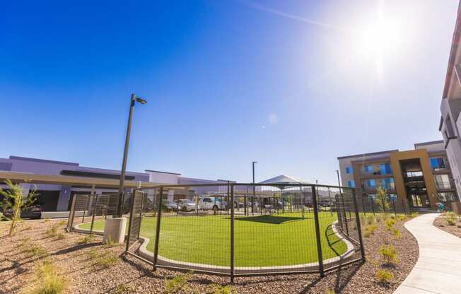 a tennis court in front of a building with a fence