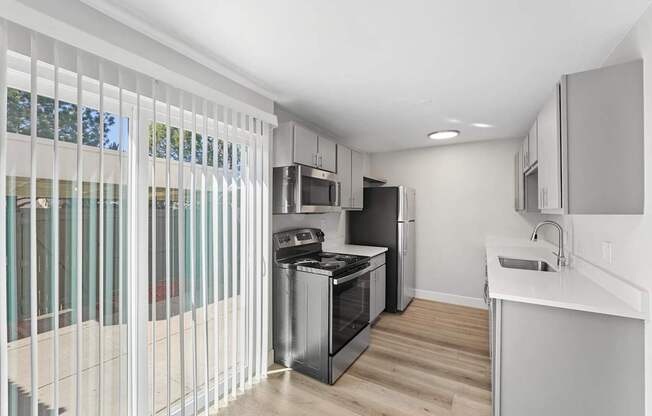 A modern kitchen with white cabinets and a stainless steel oven.