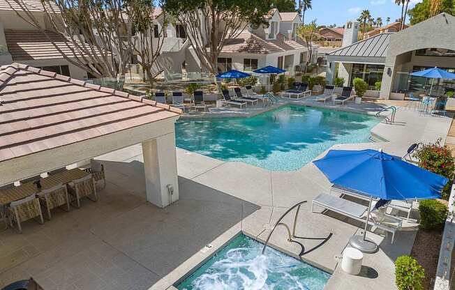 A pool with a slide and a hot tub.