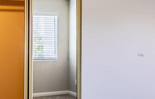 a mirror with a reflection of a window and a door