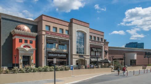 a rendering of the exterior of a building with people walking in front of it