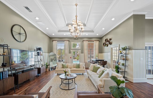 a living room with a white coffered ceiling and a chandelier