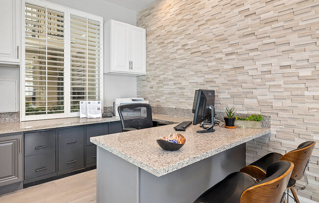 Stylish modern leasing office with same stone accent wall found in apartments