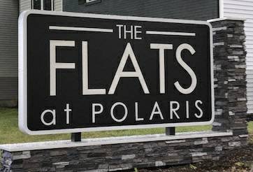 a sign for the flats at polaris in front of a house