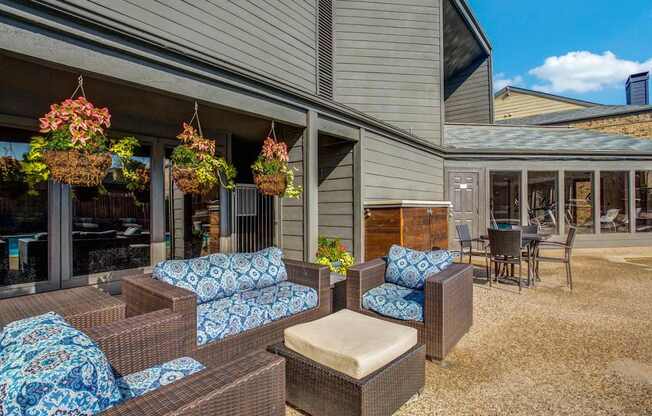 A patio area with brown wicker furniture and blue cushions.