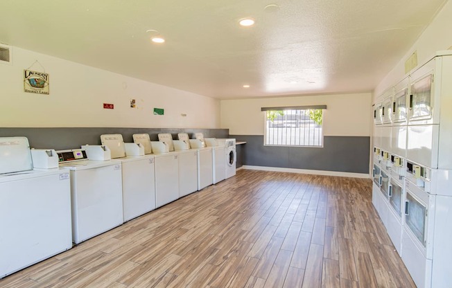 a community laundry room with washers and dryers and a wood floor