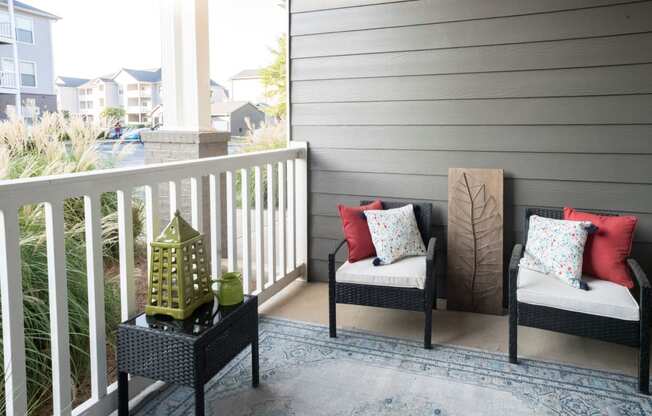 a porch with two chairs and a lantern on a balcony at The Shallowford, Chattanooga, 37421