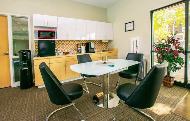 A dining room with a white table and black chairs.