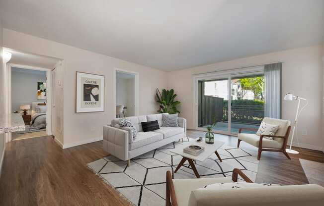 a living room with white furniture and a sliding glass door