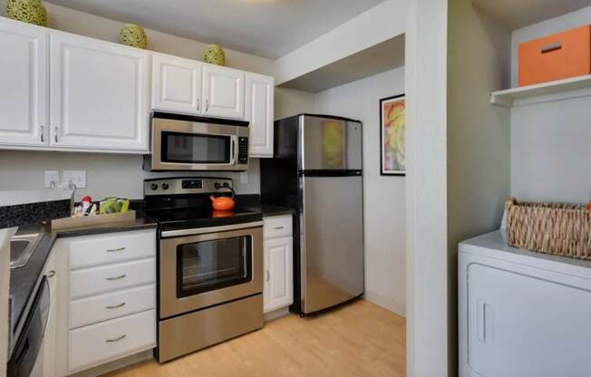 A kitchen with white cabinets and a black stove top.