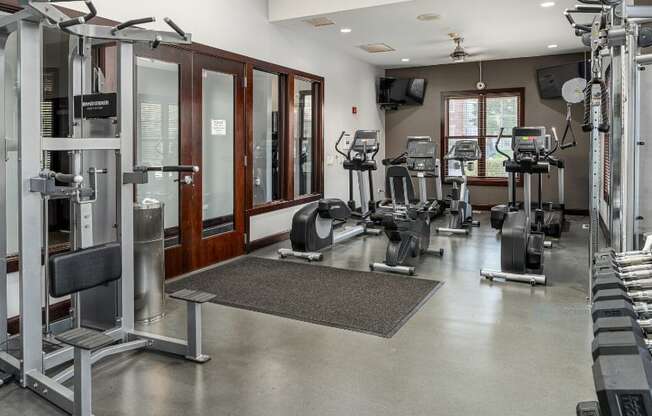 a gym with weights and cardio equipment in a building