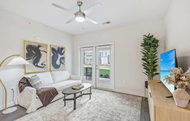 a living room with a white couch and a ceiling fan