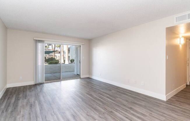 A room with a sliding glass door leading to a balcony.